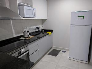 亚松森Impecable y nuevo, zona aeropuerto!的白色的厨房配有冰箱和微波炉。