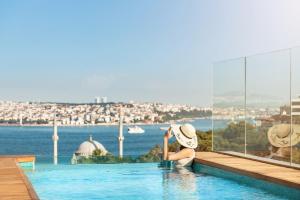 伊斯坦布尔伊斯坦布尔博斯普鲁斯海峡丽思卡尔顿酒店的水景游泳池中的女人