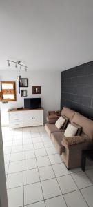 洛斯·亚诺斯·德·阿里丹Casa Sandra en Las Norias Todoque con Wi-Fi的带沙发的客厅和白色瓷砖地板。