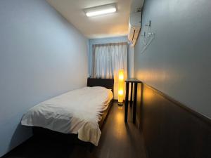 大阪太阳广场2号酒店的一间小卧室,配有一张床和一个光线