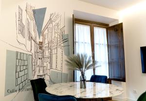 托莱多Cervantes 5 Collection Delux - Toletum的一间设有桌子和墙上绘图的用餐室