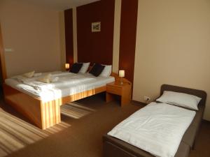 诺茨瓦约Panorama Hotel Noszvaj的两张位于酒店客房内的单人床,配有四柱床