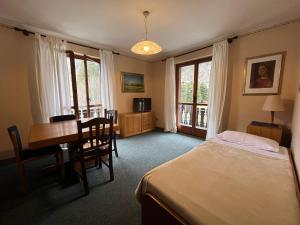坎波多尔奇诺San Luigi - Rooms & Apartments的一间卧室配有一张床、一张桌子和一张桌子