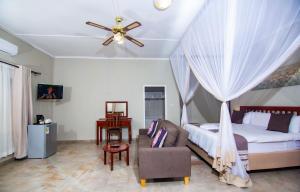 维多利亚瀑布Dzimbahwe Guest Lodge的一间卧室配有一张床和吊扇