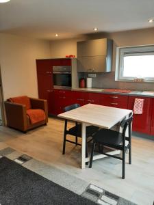 KlimmenAppartement Oase的厨房配有红色橱柜和桌椅