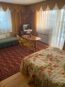MizernaNoclegi u Janika的酒店客房配有床、桌子和桌子。