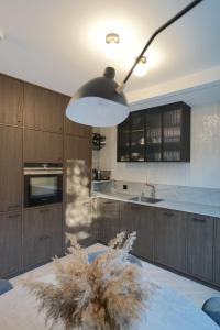 奈达A T Ò K V Ė P I S的厨房配有木制橱柜和大型灯具