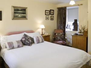 Whitehills阿什利酒店的卧室配有一张白色大床和一把椅子