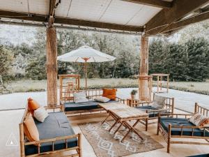 拉卡沃Lodg'ing Nature Camp Dordogne的庭院配有桌椅和遮阳伞。