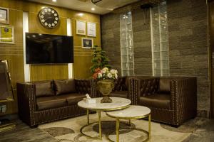 达卡Hotel Shuktara Dhaka的一间设有真皮沙发和电视的等候室