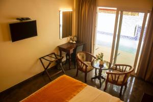 KāndūrSerene Sriperumbudur的酒店客房,配有一张床和一张桌子及椅子
