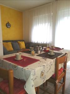 莱维科特尔梅Appartamento Verdebleu - Lago e Terme的一间设有一张桌子的房间,配有红色和白色的桌布