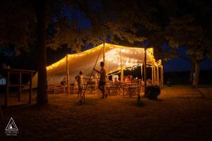 塞莱特Lodg'ing Nature Camp Châteaux de la Loire的两人在晚上站在帐篷前