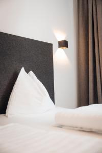 施塔姆斯Hotel Gasthof Hirschentenne的一张带白色床单的床和一盏灯