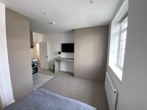 亨顿Spectacular Modern, Brand-New, 1 Bed Flat, 15 Mins Away From Central London的一间卧室配有一张床和一台电视