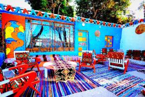 阿斯旺Nubian studio的蓝色的房间,配有五颜六色的椅子和地毯