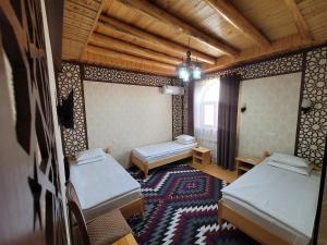 希瓦Khiva Siyovush Hotel的一间设有两张床的房间,房间铺着地毯