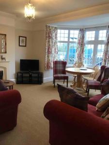 斯沃尼奇Brook Lodge的客厅配有沙发、椅子和桌子