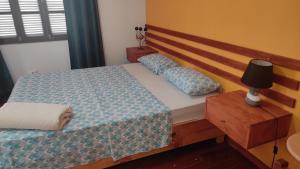 明德卢Rose`s place的一间卧室配有一张带木制床头板的床