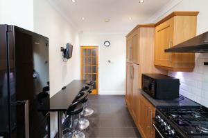 利兹OAKWOOD HOUSE Detached home in South Leeds的厨房配有木制橱柜和黑微波炉