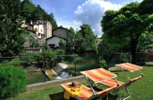 塞尼奥河畔帕拉佐洛Hotel & Ristorante EUROPA的院子里设有两把椅子和一张野餐桌