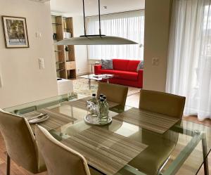 迈伦迈伦特迪亚努姆公寓的一间设有玻璃桌和红色沙发的用餐室