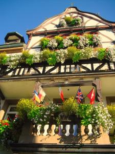 沃尔法赫克朗餐厅酒店的一座建筑,上面有很多植物和旗帜