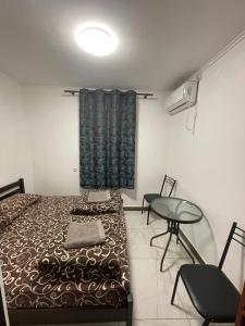 乌曼岛Shaarei Zion的一间卧室配有一张床、一张桌子和一个窗户。