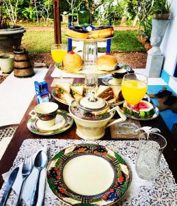 贝鲁沃勒Sriyan Villa的餐桌,带食物盘和橙汁杯