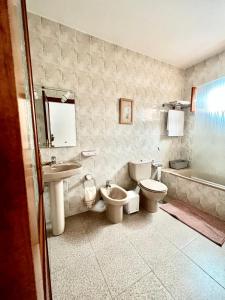 蓬塔穆赫雷斯Casa Los Jameos的浴室设有2个卫生间、水槽和浴缸。