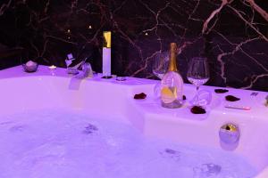 罗马AlbaDea Suites&Jacuzzi的浴缸装满酒杯和葡萄酒瓶