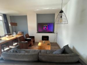 阿纳姆Appartement Arnhem的客厅配有沙发和墙上的电视