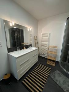 迪塞Gite comme chez soi Ducey les Chèris的浴室设有白色水槽和镜子