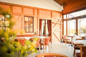 林巴-奥贝尔夫罗纳Schneiderlein Hotel的餐厅设有桌椅和窗户。