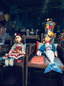 邦比尼亚斯Tainha da Praia Aparthotel的两个娃娃坐在房间里椅子上