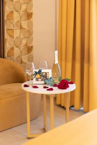 罗马AlbaDea Suites&Jacuzzi的一张桌子,上面放有两杯酒和一瓶酒