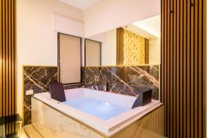 罗马AlbaDea Suites&Jacuzzi的带浴缸和镜子的浴室