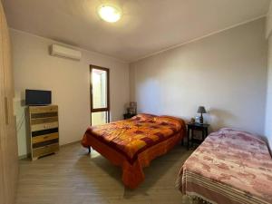 圣温琴佐Moderno trilocale a 20 metri dal mare的一间卧室配有两张床、一个梳妆台和电视。