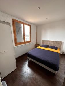 梅塔比耶Place Royale pour 10 à 12 personnes à 30 mèt des pistes de Ski et Vtt的一间卧室设有一张床和一个窗口