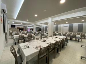 圣马蒂诺－因彭西利斯圣托扬尼酒店的一间设有白色桌椅的用餐室