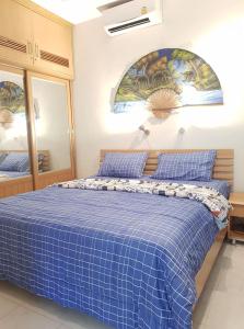 罗勇House in Ban Phe, Thailand的一间卧室配有蓝色的床和蓝色的毯子