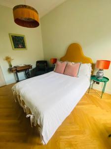 卡伦德本安楼住宿加早餐旅馆的卧室配有带粉红色枕头的大型白色床
