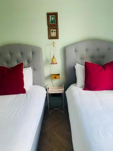卡伦德本安楼住宿加早餐旅馆的客房内的两张床和红色枕头