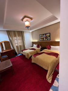 米德勒特阿斯玛古堡酒店的酒店客房,设有两张床,铺有红地毯。