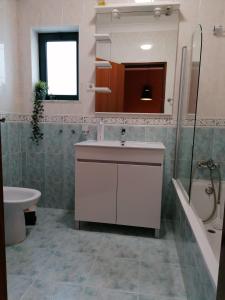 拉戈斯Apartamento Nora的浴室配有盥洗盆、卫生间和浴缸。