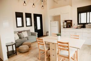 HaZore‘imCozy Beautiful Guest House的厨房以及带桌椅的起居室。