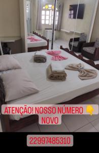 马卡埃Pousada nascente do sol的一间卧室配有两张带毛巾的床