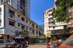孟买Hotel Gemini的一条城市街道,有停放的摩托车和建筑