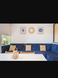 埃尔波提尔Apartamento en el Portil的一间带桌子和蓝色沙发的用餐室