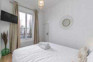 维勒蒙布勒MBA Splendide Appart - Le Raincy - Banlieue Paris的卧室配有一张带镜子的白色床和窗户。